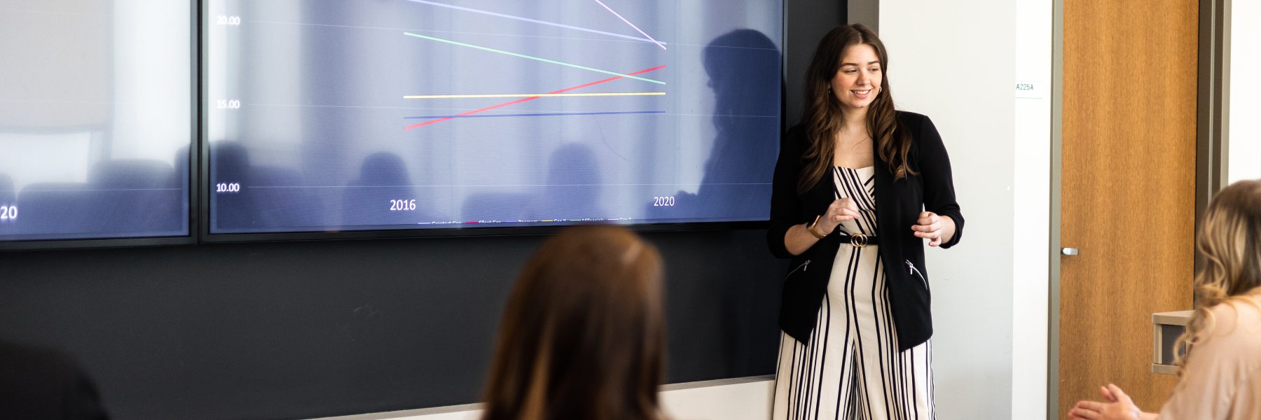 Presenter wearing stripes in front of screen